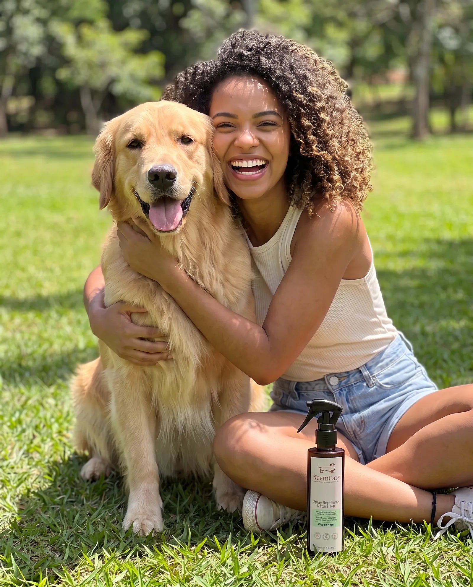 Tutora abraça o golden retriever na grama do parque, com o repelente NeemCare ao lado